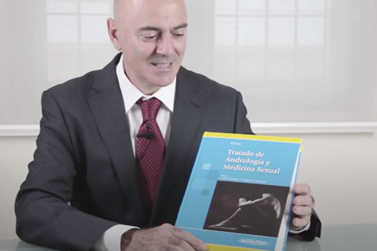 Dr. Natalio Cruz sosteniendo su libro, tratado de Andrología y medicina sexual
